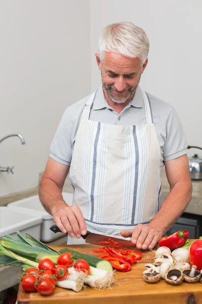 Mogen man hugga grönsaker i köket — Stockfoto