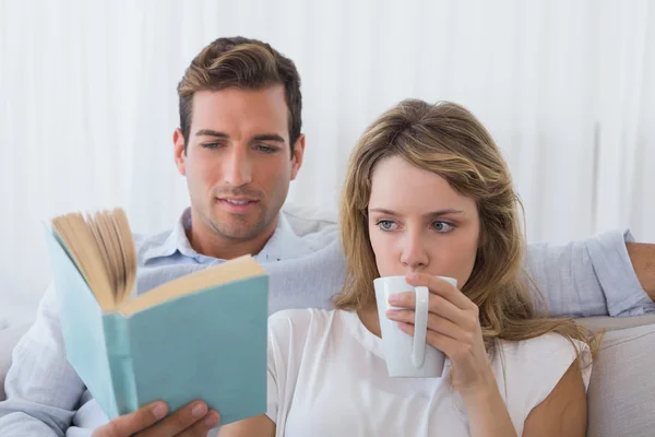 Livro de leitura de casal no sofá — Fotografia de Stock