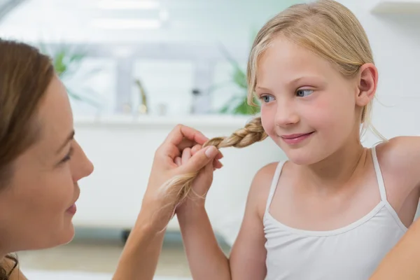 Primer plano de una mujer ajustando el pelo de una linda niña — Foto de Stock