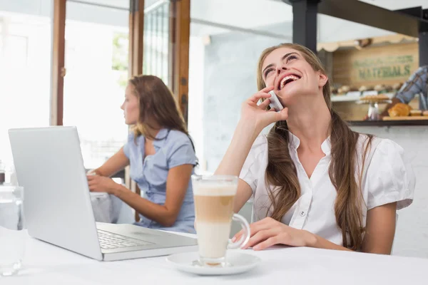 Kahve dükkanında cep telefonu kullanan kadın — Stok fotoğraf