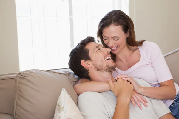 Liebendes junges Paar sitzt auf Couch — Stockfoto