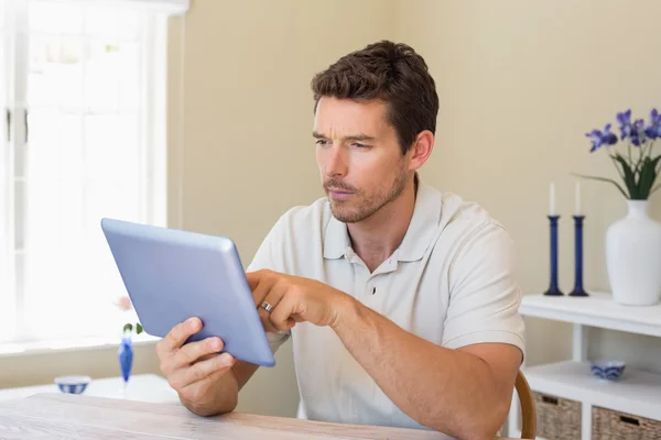 Hombre concentrado usando tableta digital en la mesa — Foto de Stock