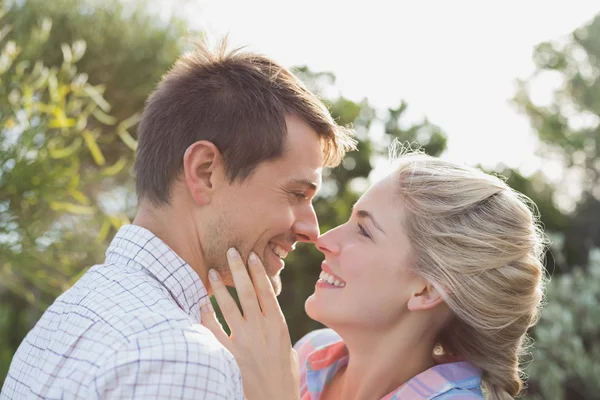 Smiling young couple looking at each other in park — Stock Photo, Image