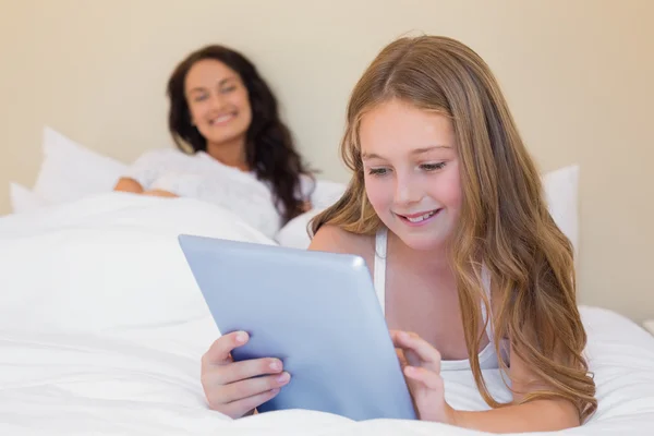 Meisje met digitale tablet in bed — Stockfoto