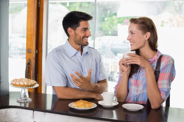 Pareja sonriente con café y croissant en la cafetería —  Fotos de Stock