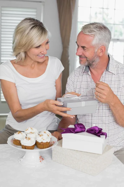 Mujer feliz dando una caja de regalo para hombre maduro —  Fotos de Stock