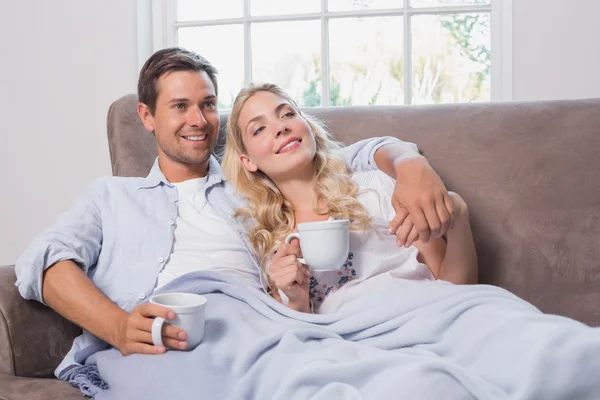 Relajada pareja amorosa con tazas de café en la sala de estar —  Fotos de Stock