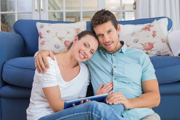 Счастливая пара с помощью цифрового планшета в гостиной — стоковое фото
