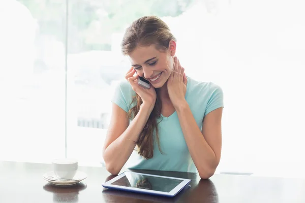 Mulher com xícara de café usando tablet digital e celular no café — Fotografia de Stock