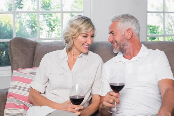 リビング ルームでガラスのワインと幸せなリラックスした成熟したカップル — ストック写真