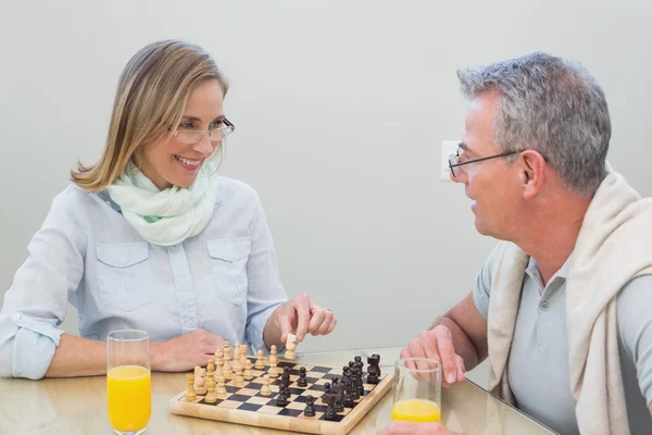 Пара, играющая в шахматы с апельсиновым соком — стоковое фото