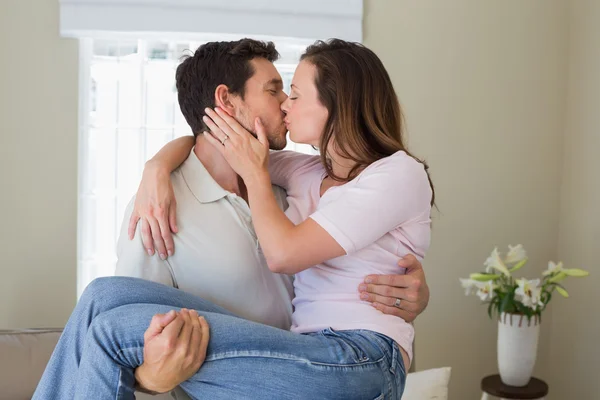 Homem carregando mulher como ele a beija — Fotografia de Stock