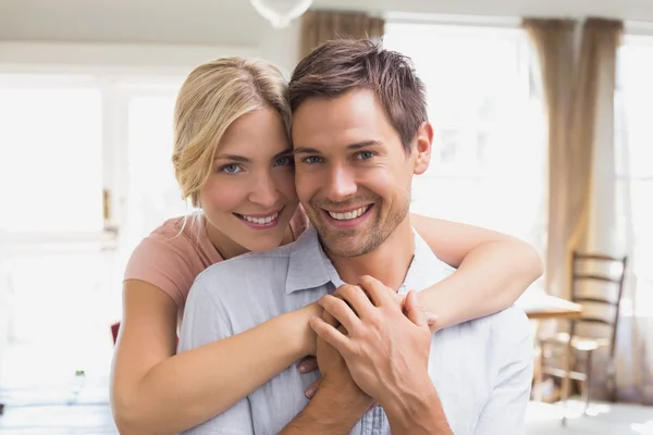 Woman embracing man from behind at home — Stock Photo, Image