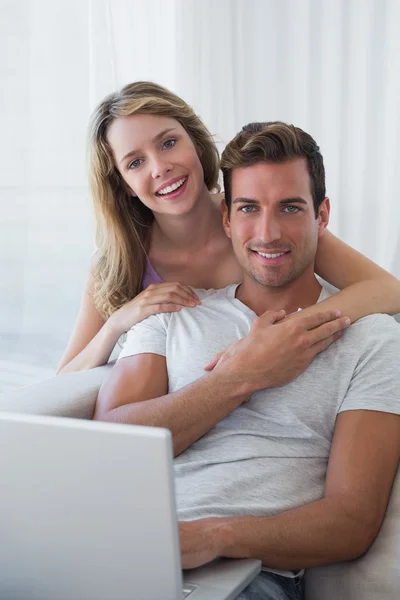 Casal relaxado usando laptop no sofá — Fotografia de Stock