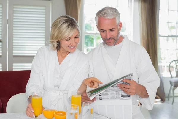 Paar liest Zeitung beim Frühstück — Stockfoto