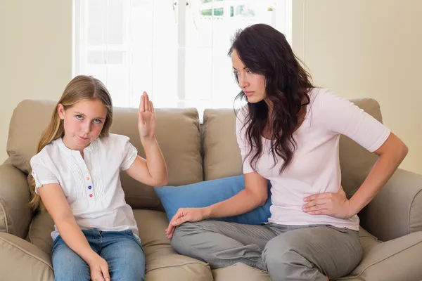 Tjej visar stopp gest till mor på soffa — Stockfoto