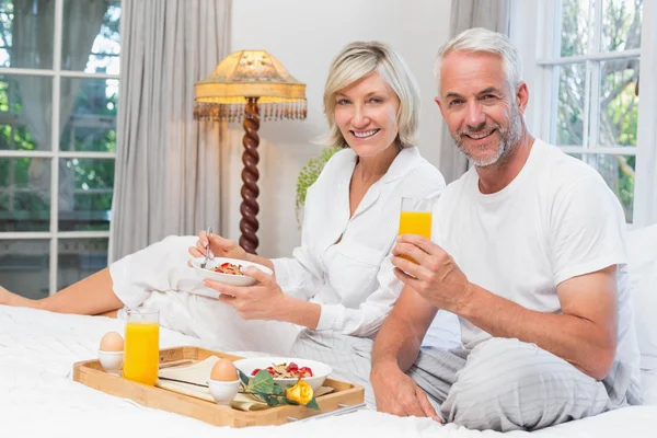 Coppia matura che fa colazione a letto — Foto Stock