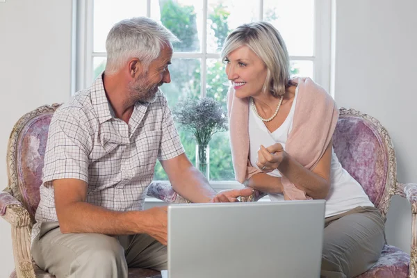 Par diskutera medan du använder laptop hemma — Stockfoto