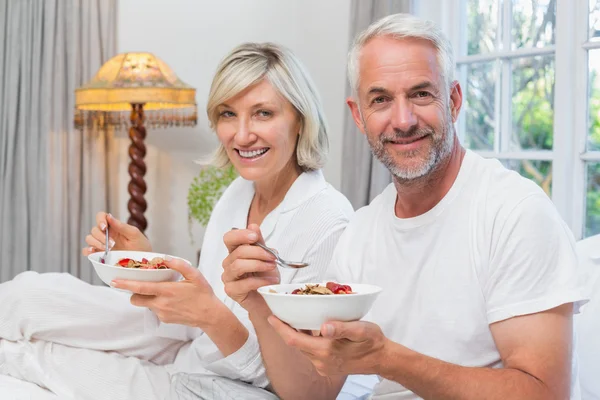 Mature couple having breakfast in bed — Stock Photo, Image