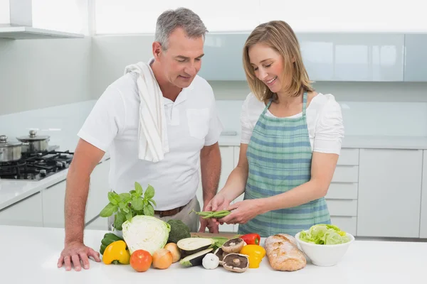 Szczęśliwa para przygotowuje jedzenie razem w kuchni — Zdjęcie stockowe