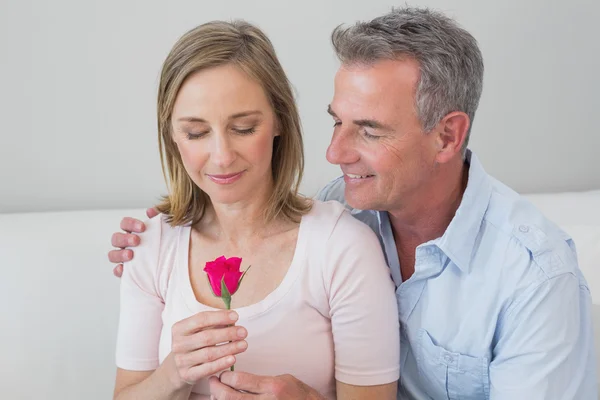 Casal romântico feliz com uma flor — Fotografia de Stock