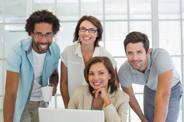 Glimlachende mensen uit het bedrijfsleven met behulp van laptop op kantoor — Stockfoto