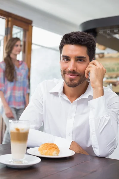 Uomo sorridente utilizzando il telefono cellulare in caffetteria — Foto Stock