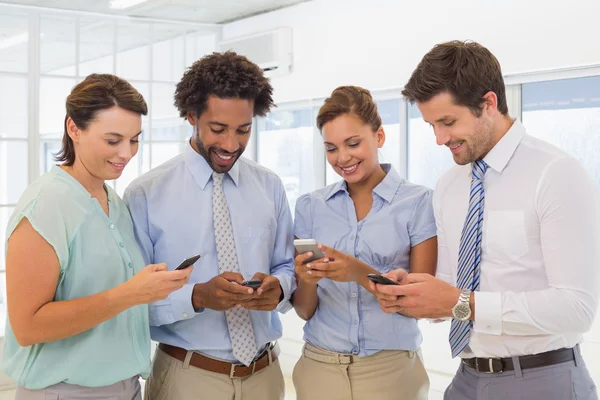 Business colleagues text messaging in office — Stock Photo, Image