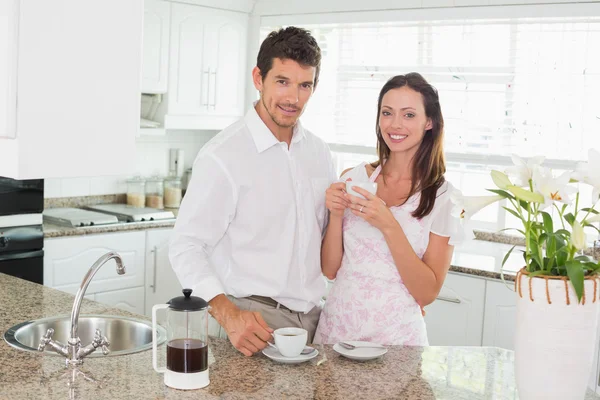 Happy young couple having coffee in kitchen — Stock Photo, Image