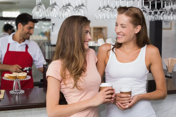 Cheerful friends with barista at counter in coffee shop — Stock Photo, Image