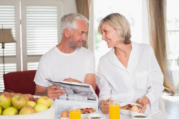 Couple reading newspaper while having breakfast — Stock Photo, Image