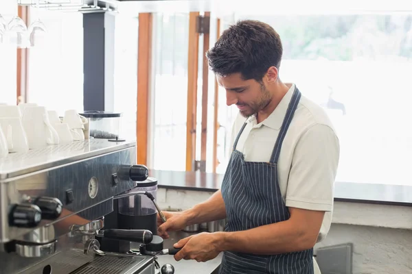 Улыбающийся бариста готовит эспрессо в кафе — стоковое фото