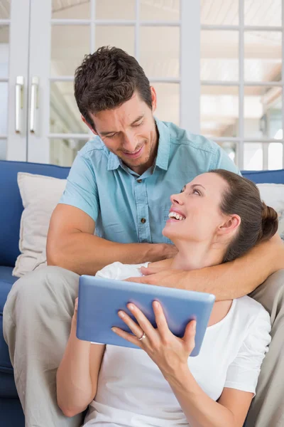 Pareja feliz usando tableta digital en el sofá —  Fotos de Stock