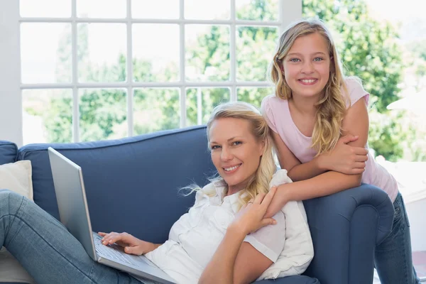 Mujer feliz e hija con el ordenador portátil —  Fotos de Stock