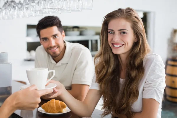 Hand giving coffee to a couple at coffee shop — Stock Photo, Image