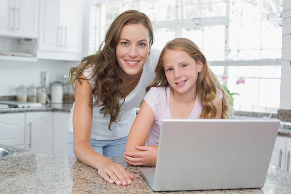 Portret szczęśliwy matka i córka korzysta z laptopa w kuchni — Zdjęcie stockowe