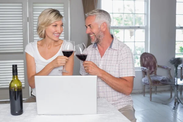 Зрелая пара пьет бокалы с вином дома — стоковое фото