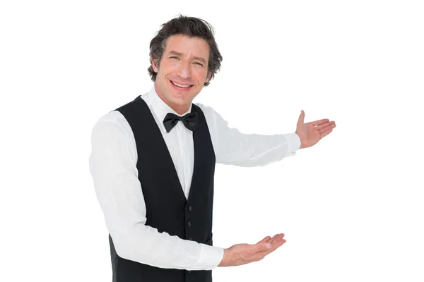 Happy waiter welcoming over white background — Stock Photo, Image