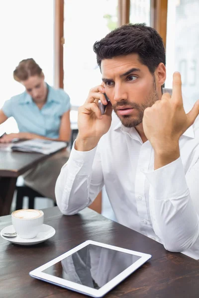 Hombre serio usando el teléfono móvil en la cafetería — Foto de Stock