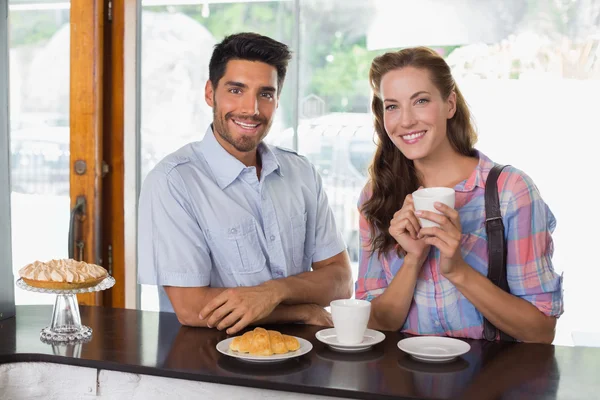 微笑的情侣与咖啡和羊角面包在咖啡店里 — 图库照片