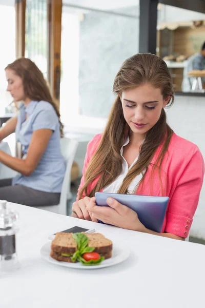 Kobieta za pomocą cyfrowego tabletu w kawiarni — Zdjęcie stockowe