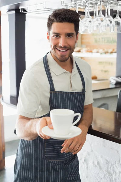 Lächelnder Kellner mit Kaffeetasse im Café — Stockfoto