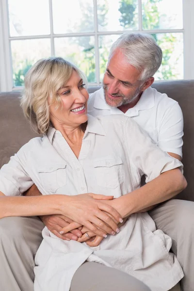 Älterer Mann umarmt Frau von hinten im Wohnzimmer — Stockfoto