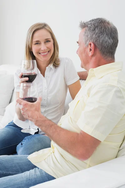 Relaxed couple with wine glasses sitting on sofa — Stock Photo, Image