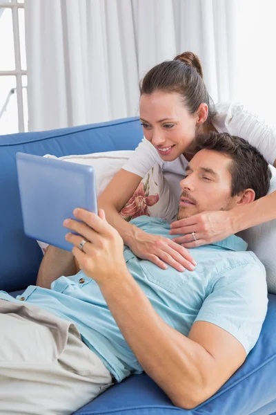 Casal amoroso com tablet digital na sala de estar em casa — Fotografia de Stock