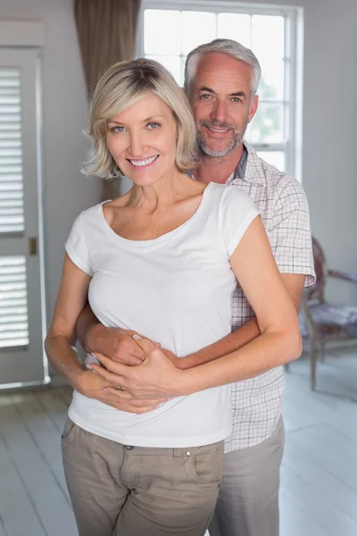 Mature man embracing woman at home — Stock Photo, Image