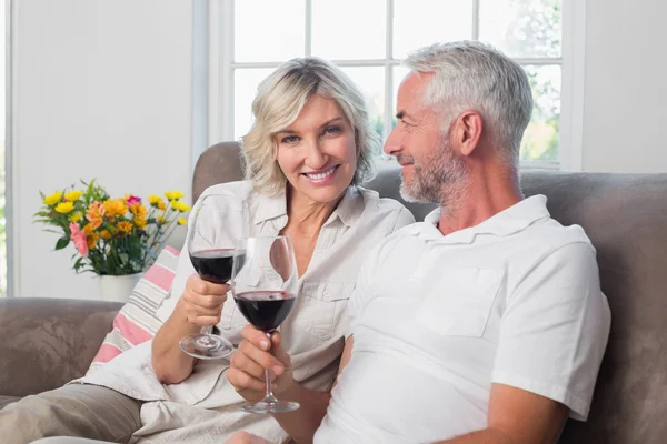 Happy loving mature couple with wine glasses in living room — Stock Photo, Image