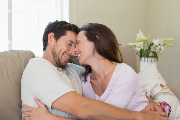 Cheerful loving couple on couch at home — Stock Photo, Image
