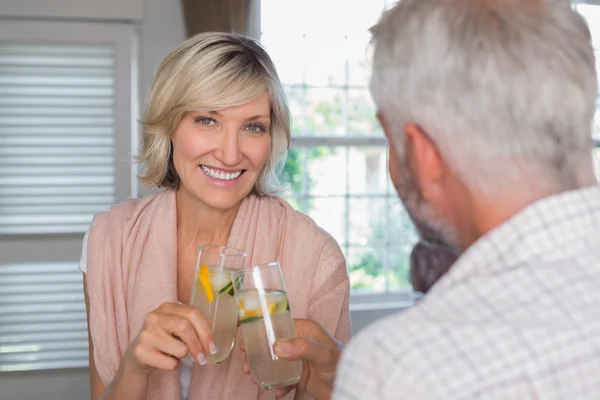 Улыбающаяся женщина со взрослым мужчиной, пьющим напитки — стоковое фото