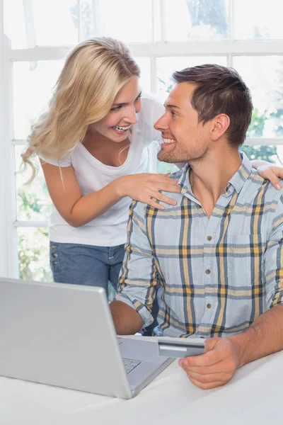 Sonriendo joven pareja haciendo compras en línea en casa —  Fotos de Stock